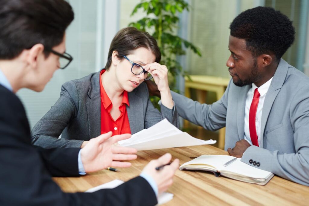 Patient consulting with a medical malpractice attorney while reviewing medical records, healthcare documents, and legal paperwork to evaluate a potential malpractice claim.
