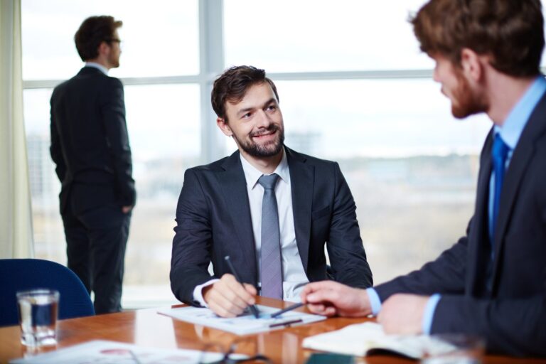 Business lawyer meeting with clients in a modern office, reviewing legal contracts, business documents, and corporate agreements while providing professional legal advice.